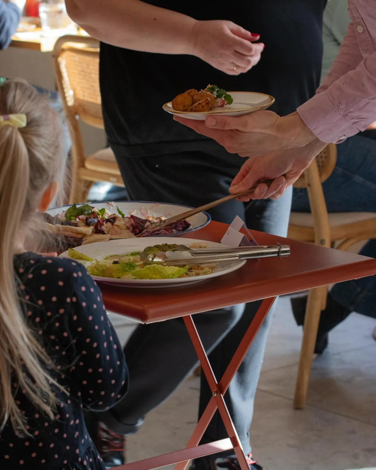 Bufetes ēdieni uz šķīvjiem un viesi pie galda Agates Āzijas bufetē